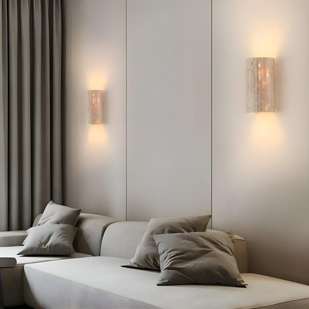 Pair of natural stone wall sconces casting warm LED glow above sofa